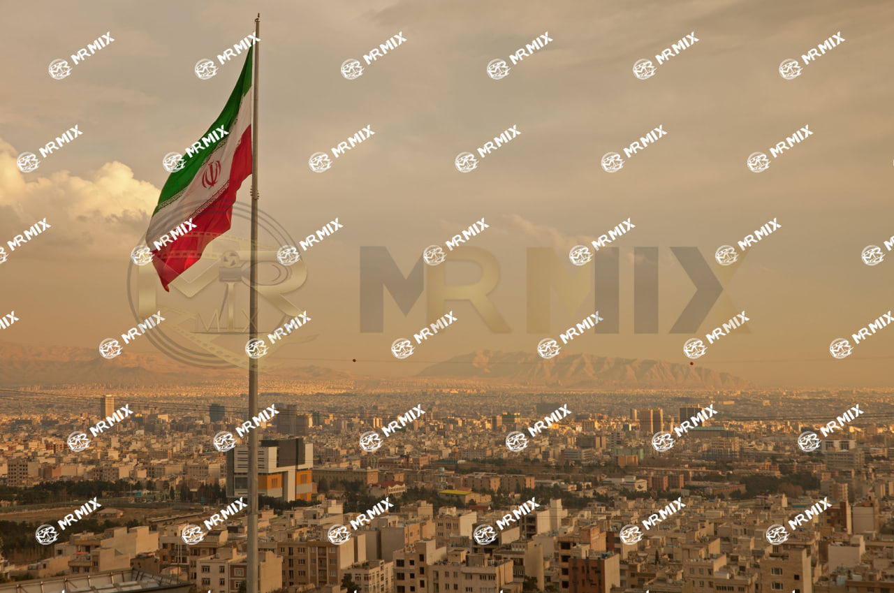 عکس استوک پرچم ایران در باد بر فراز خط آسمان تهران