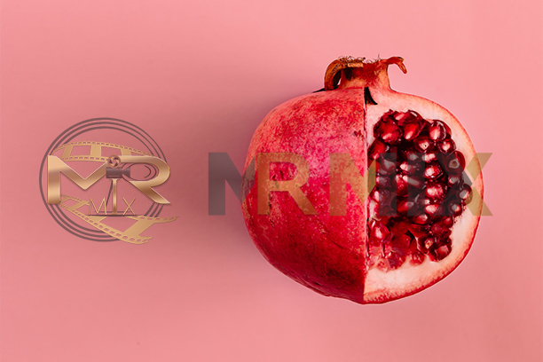 عکس استوک میوه انار قرمز در زمینه صورتی پاستلی شب یلدا