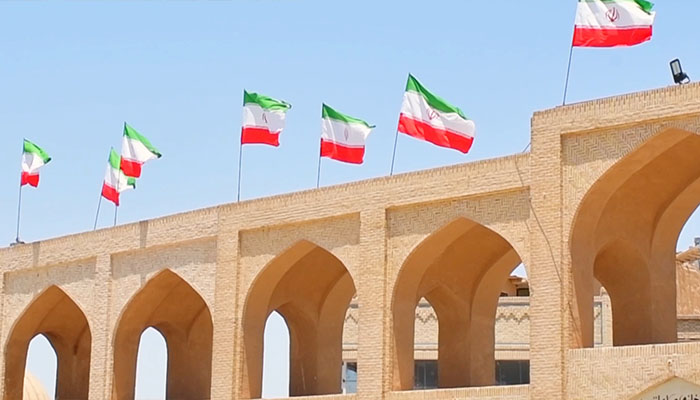 فوتیج پرچم ایران در پشت بام ساختمان به اهتزاز درآمده