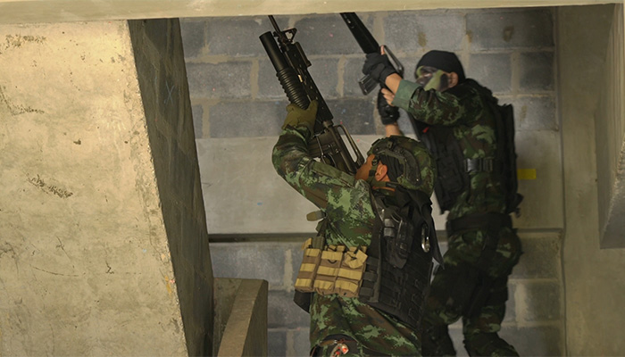 فوتیج سربازی که اسلحه و لباس زره جنگی در دست دارد از پله بالا میرود