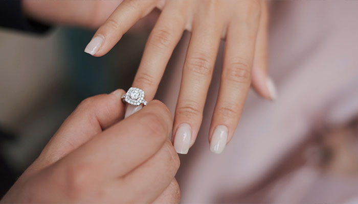 فوتیج حلقه های ازدواج داماد حلقه را در انگشت عروس قرار می دهد