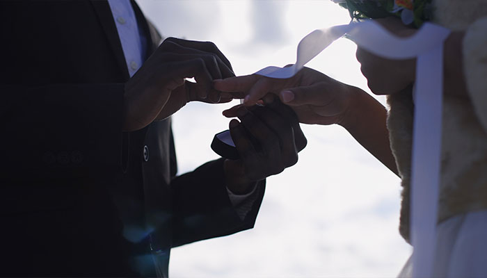 فوتیج داماد فضای باز حلقه ازدواج را روی انگشت عروس می‌گذارد