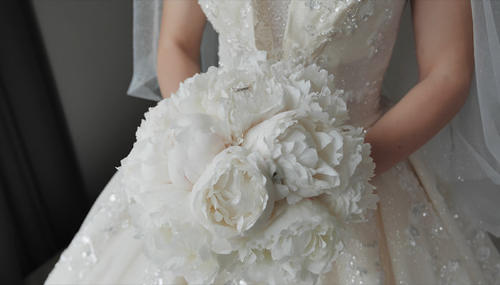 فوتیج عروس در لباس عروسی مجلل با یک دسته گل سفید