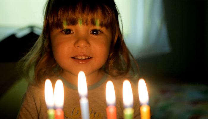 فوتیج پسر بچه در جشن تولد شمع های کیک تولد را فوت می کند