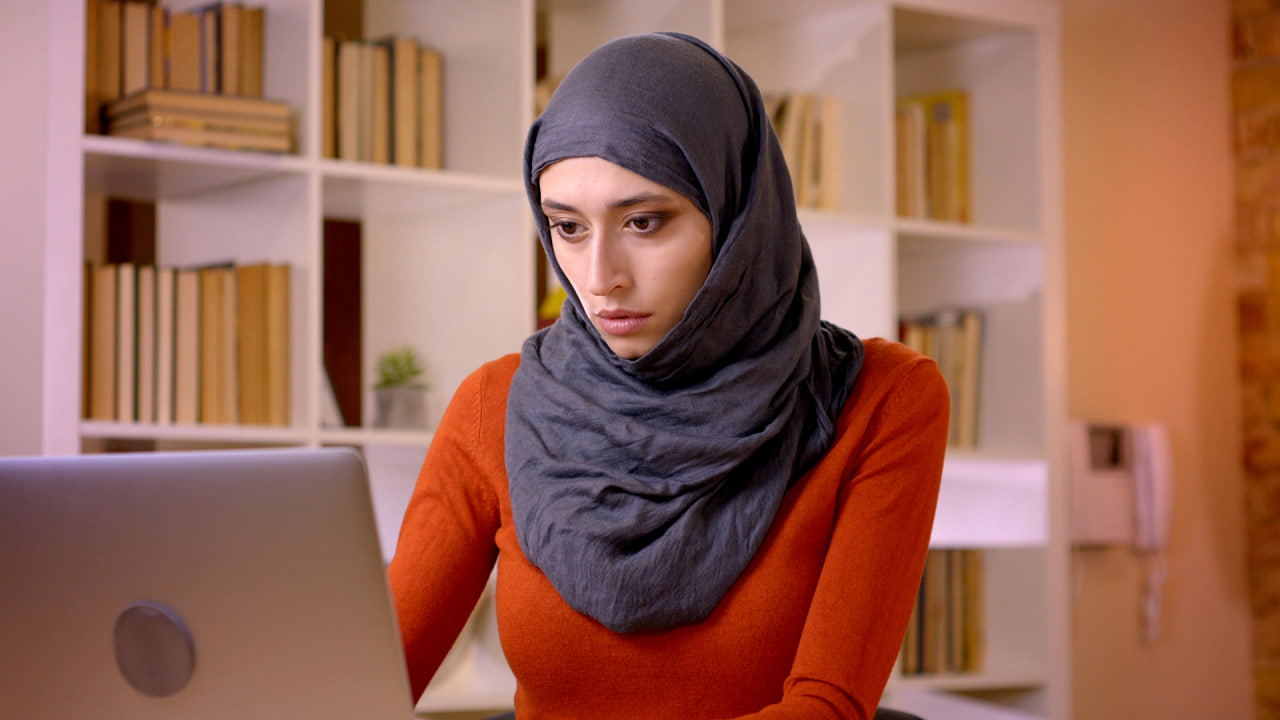 فوتیج از کارمند زن مسلمان که با لپ‌تاپ کار می‌کند