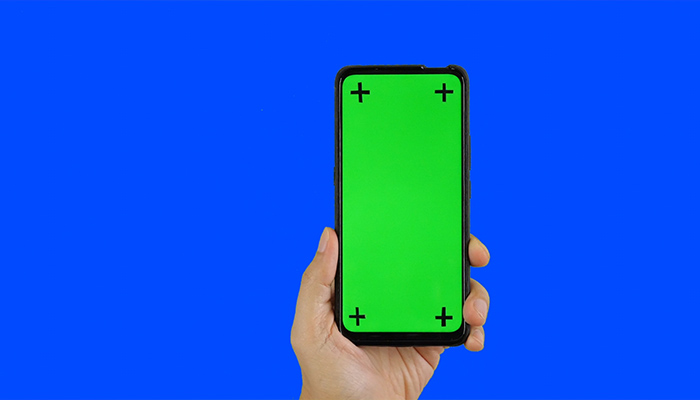 فوتیج پرده سبز دست مردی که یک گوشی با صفحه سبز و پس زمینه آبی